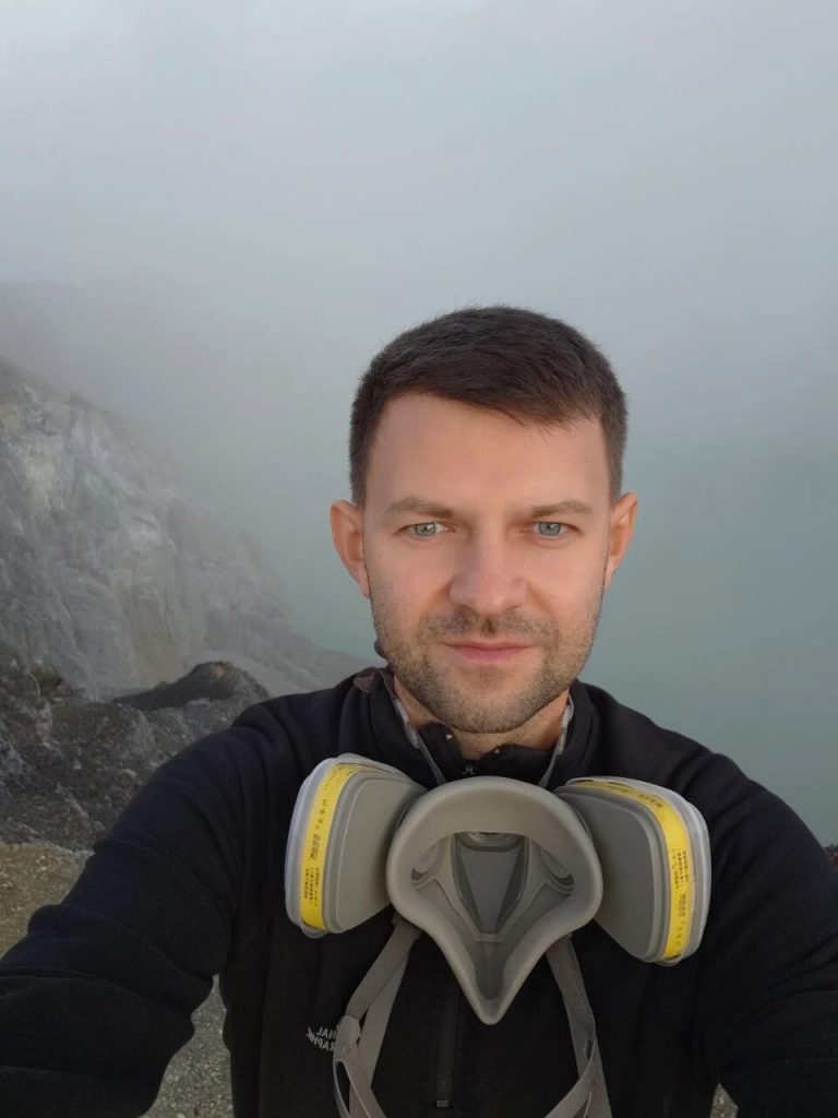 Dmitriy at the rim of the Ijen volcano crater, respirator around his neck